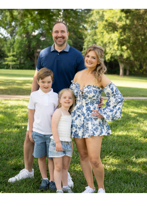 John with his family, standing on a lawn on a sunny day