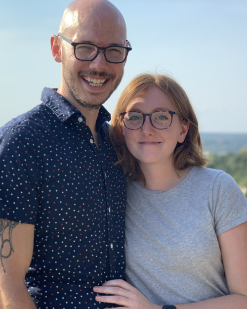 Ricky, smiling with his wife on a sunny day